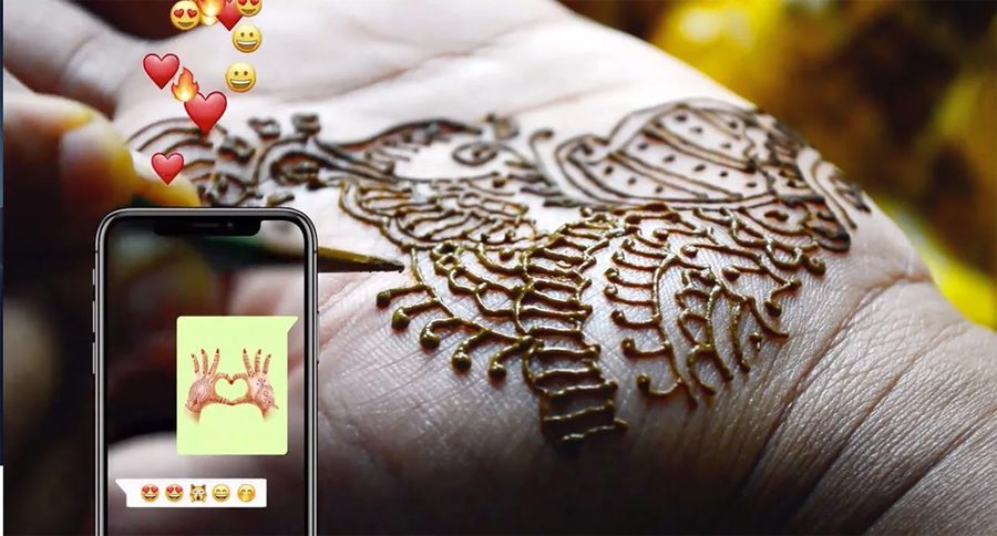 Henna being applied to a hand, with a Mojimix sticker shared on a phone
